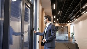 Businessman in a formal suit unlocking door in modern business center using mobile phone application. Scanning open smartphone with mock up screen app. Smart electronic locks with keyless access - Powered by Shutterstock - Get 15% off with code: PIKWIZARD15