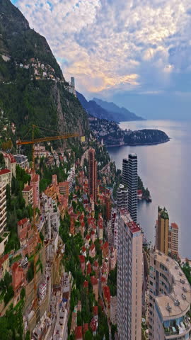 Aerial view of the city center of Monaco. Establishing shot showcases luxury yachts moored in Monaco Bay, the Palais Princier de Monaco, and luxury apartment buildings of Monte Carlo