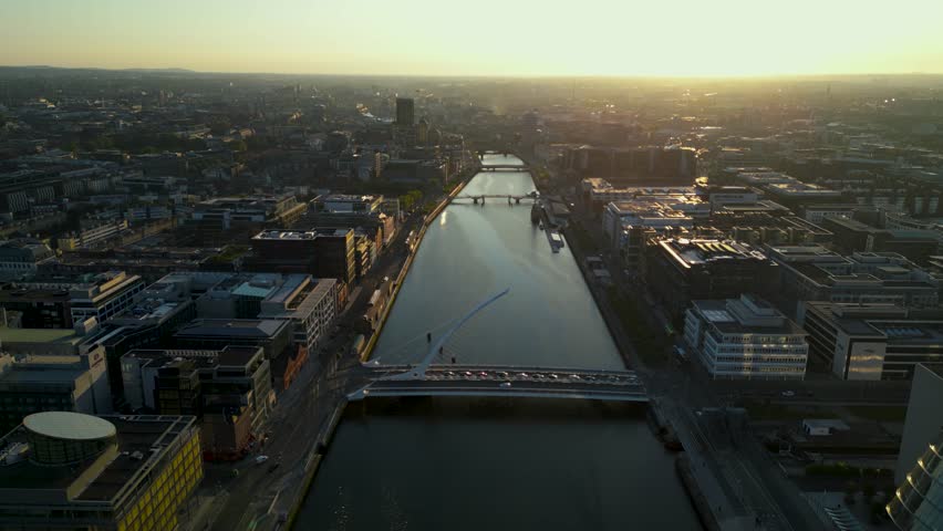 Aerial view of Samuel Beckett Bridge or Harp Bridge on Liffey river in Dublin City - Ireland during a golden sunset time.