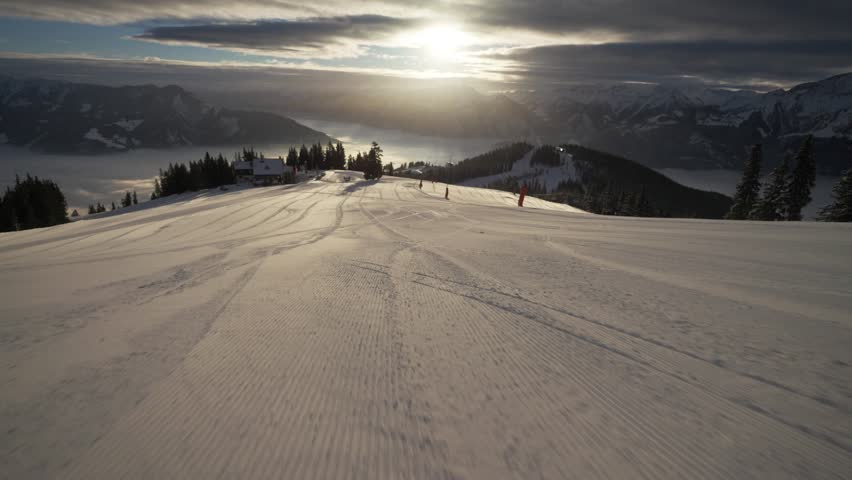 A Skier in a red uniform sliding down on a snow covered hill