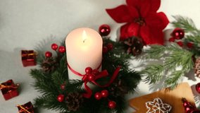Warm candle and festive pine wreath with red berries and pine cones on a white background. - Powered by Shutterstock - Get 15% off with code: PIKWIZARD15