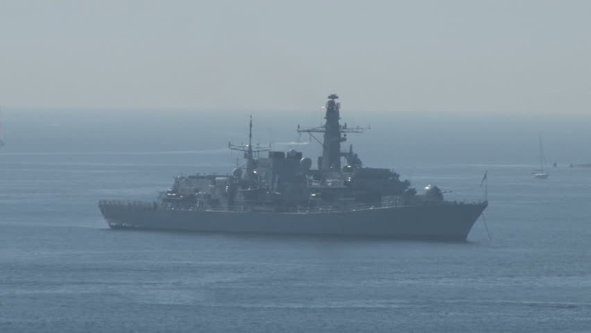 A warship harbored on a sunny day at sea.