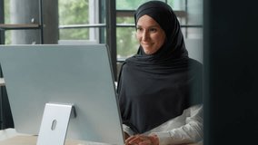 Happy Arabian business woman in hijab typing computer keyboard Muslim Islamic businesswoman female girl employer work smiling working online internet at table startup project developing use cyberspace - Powered by Shutterstock - Get 15% off with code: PIKWIZARD15