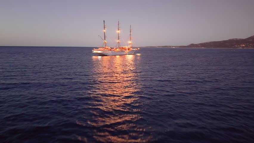 sunset ship glow, tranquil sunset voyage aboard grand threemasted vessel with reflective waters. Calvi. Corsica. France