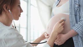Doctor examining pregnant woman holding stethoscope near big belly listening baby heartbeat. Gynecologist doctor consulting patient about pregnancy in hospital office. Visit to doctor medical checkup - Powered by Shutterstock - Get 15% off with code: PIKWIZARD15