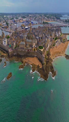  Aerial view of amazing rocky coast of the atlantic ocean in France at sunset. Establishing shot of Bretagne. Drone flying up above the rocks with waves crashing on them in North Brittany