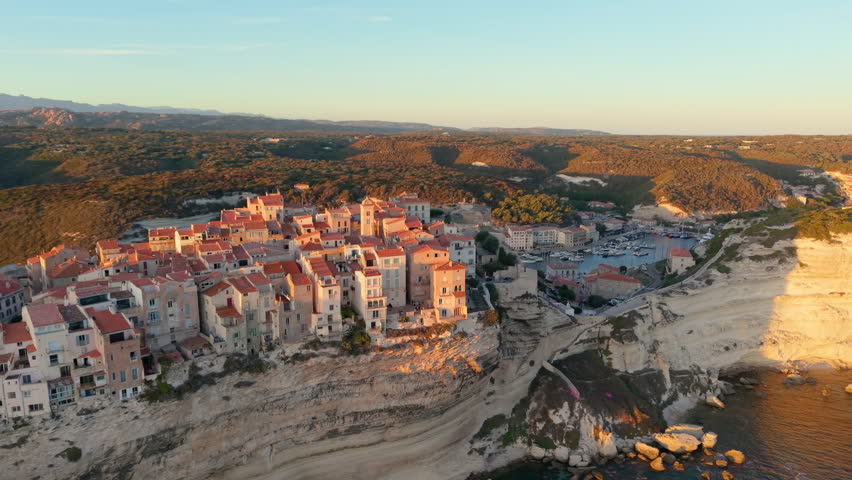 Aerial view of coastal sunset City, peaceful mediterranean coastal community with terracotta roofs during sunset. Bonifacio. France