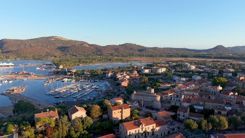 scenic aerial perspective of calm coastal town featuring bright rooftops and gentle bay waters. Porto-Vecchio. France