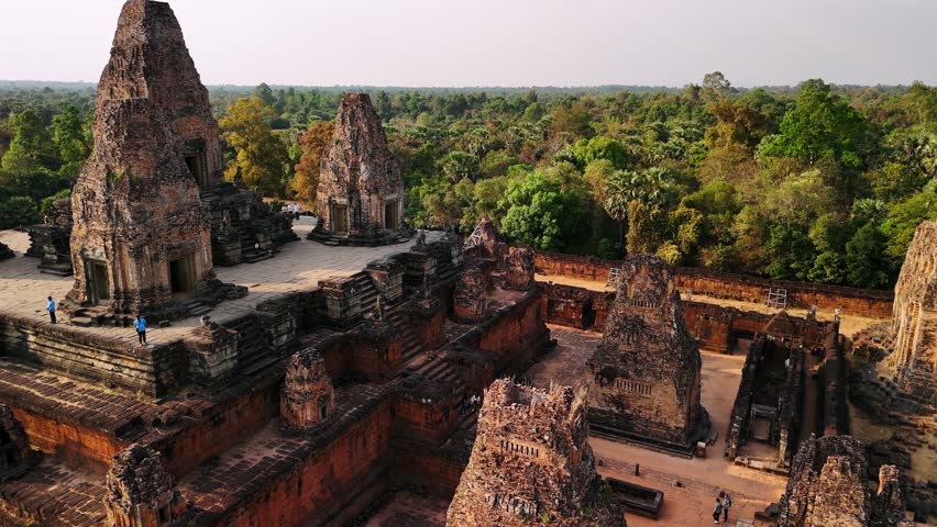 Aerial view of the ancient stone towers of the pre rup temple ruins surrounded by a dense jungle in cambodia
