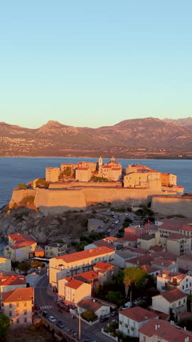 Aerial view of calvi citadel at sunrise with serene waters. Fortress with marina. Corsica. France