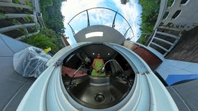 Woman in Green Dress Washing Produce at Sink Framed by Tiny Planet Angle with Curved Balcony and Jungle Surrounding. - Powered by Shutterstock - Get 15% off with code: PIKWIZARD15