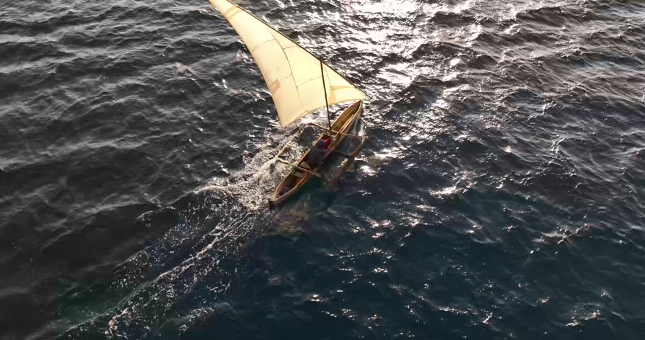 An aerial view of a Dhow boat sailing in windy weather on the coast of Mozambique in Cabo Delgado
