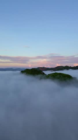 Foggy Hills Landscape Under Cloudy Sky. Aerial View of Misty Mountains at Sunrise in Gorontalo, Indonesia
