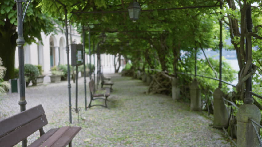 Lake como walkway under pergola, defocused soft bokeh garden; background backdrop copyspace calm.