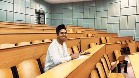 A muslim young student in the hall room noting the class lectures || Young Muslim men with Arab attires Looking Malaysian - Powered by Shutterstock - Get 15% off with code: PIKWIZARD15