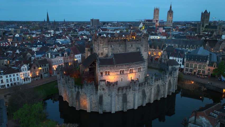 night drone view of Ghent medieval fortress in Belgium with evening illumination, unesco world heritage site in Belgium, travel in the Flemish region
