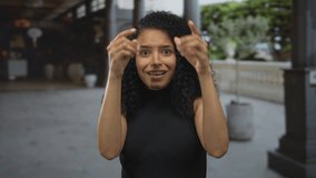 Woman smiling outdoors, expressing joy with curly hair, captured in a candid moment, showcasing natural beauty and happiness in an urban setting. - Powered by Shutterstock - Get 15% off with code: PIKWIZARD15
