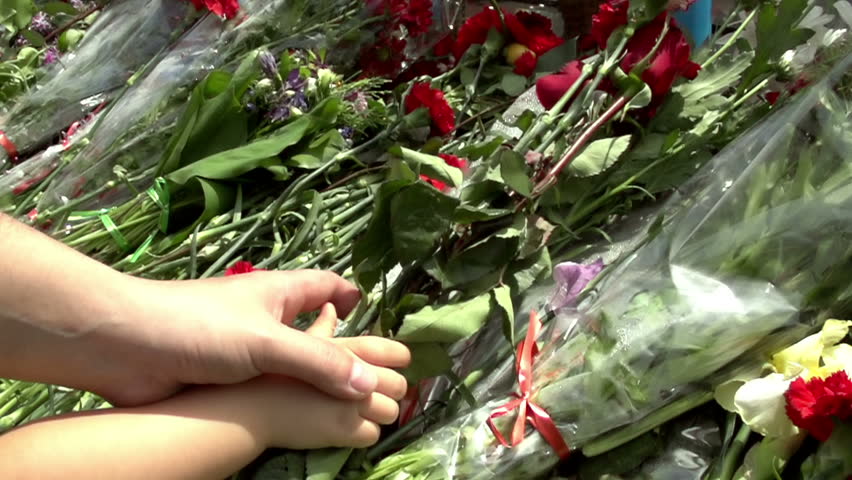 Placing Flowers. Hand adult helps the child to put flowers on memorial. Slow Motion at a rate of 480 fps | Shutterstock HD Video #3942881