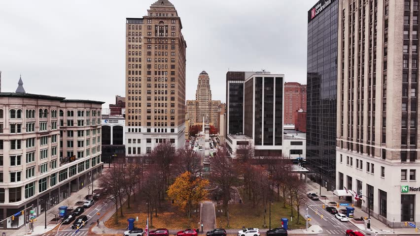 A high-resolution drone clip capturing downtown Buffalo, New York, with a clear view facing north along Niagara Square toward the historic Art Deco–style Buffalo City Hall. The image showcases a mix o