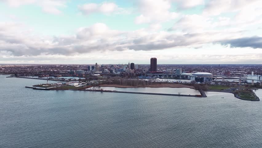 A wide aerial drone view of Buffalo, New York, showcasing the city skyline from the waterfront along the Buffalo River and Canalside district. The image includes the downtown high-rises, historic arch