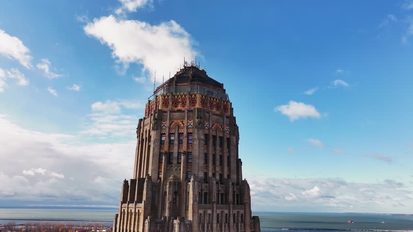 A high-resolution drone aerial shot of Buffalo City Hall in Buffalo, New York, showcasing the building’s distinctive Art Deco architecture. The camera captures the ornate upper stories and decorative 