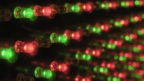 Angled macro perspective of an RGB LED panel showing rows of red green and blue diodes flickering in sequence with sharp focus in the foreground and soft bokeh in the background on a dark surface. - Powered by Shutterstock - Get 15% off with code: PIKWIZARD15