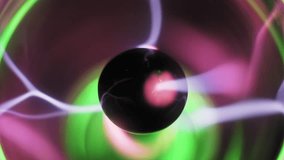 Macro view of a plasma ball central electrode emitting pink and purple electric bolts. Wavy ionized gas filaments and streamers with green light glow on a dark background. High voltage energy display. - Powered by Shutterstock - Get 15% off with code: PIKWIZARD15