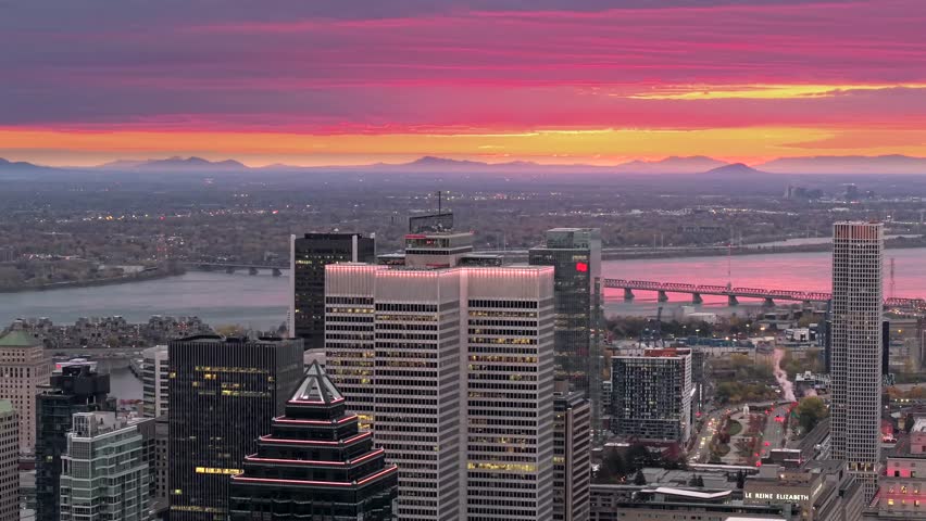 Aerial sunrise view of Montreal skyline with St Lawrence River bridges
