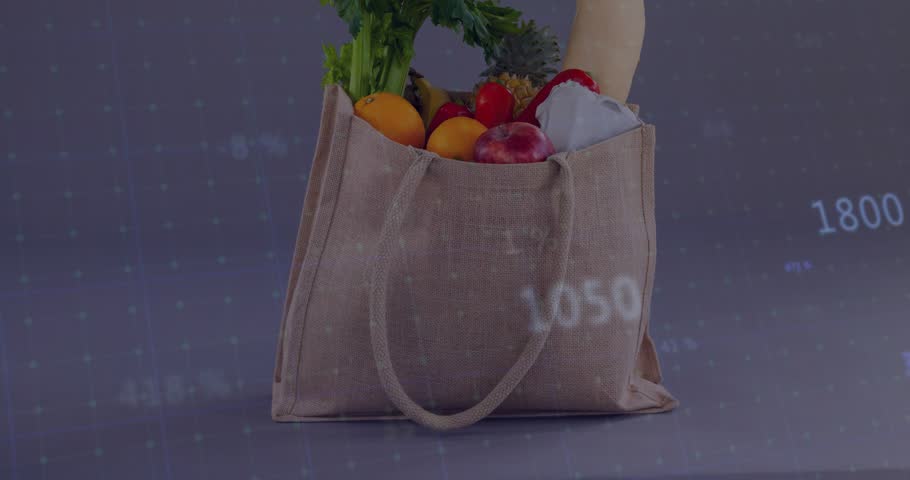 Data feed starting graphs sliding across reusable tote, numbers changing to show grocery sales. Bag, fruits, vegetables, flatlay, charts, overlays, figures