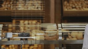 Woman entering frame, raising card and holding baguettes in bakery, charts over card showing sales. Bread, shopper, retail, display, counter, graphs, data - Powered by Shutterstock - Get 15% off with code: PIKWIZARD15
