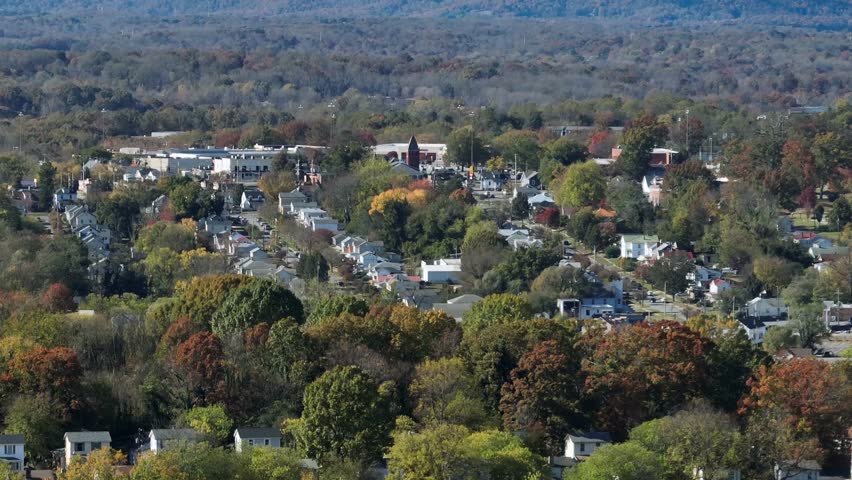 Aerial wide shot of American city neighborhood with colored trees in autumn season. Wide shot.