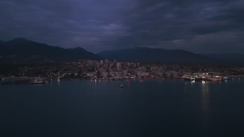 Super wide aerial shot of The Shipyards and Lonsdale Quay Market in North Vancouver at twilight in British Columbia, Canada. 4K