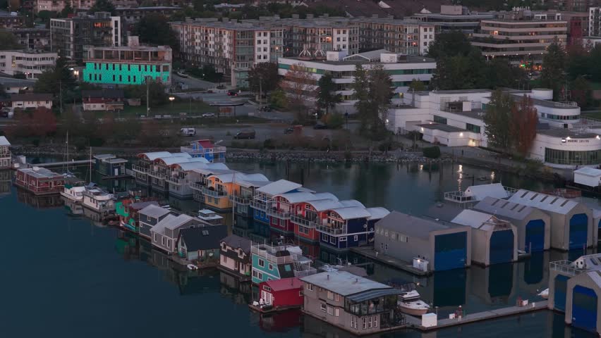 Close up aerial panning shot of floating homes at the Mosquito Creek Marina during twilight in North Vancouver, British Columbia, Canada. 4K