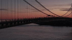 Drone hovering at roadway height beside the Verrazzano-Narrows Bridge, slight lateral orbit with gentle ascend descend, 70mm telephoto compressing steady traffic against The Narrows and Lower New Y... - Powered by Shutterstock - Get 15% off with code: PIKWIZARD15