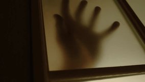 Silhouetted hand pressing against frosted glass door, creating a haunting, eerie atmosphere that evokes fear, nightmares, and classic horror themes. - Powered by Shutterstock - Get 15% off with code: PIKWIZARD15