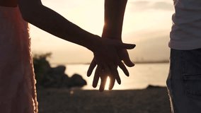 A close-up of male and female hands gently touching against a warm sunset, symbolizing love, romance, intimacy, connection, and tender human relationships in a serene outdoor setting. - Powered by Shutterstock - Get 15% off with code: PIKWIZARD15
