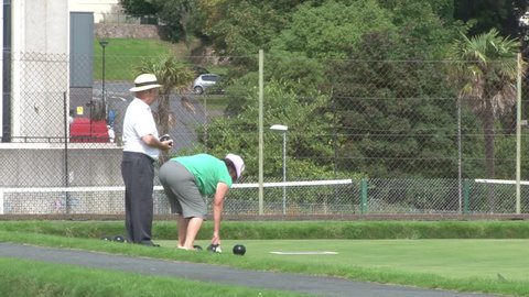DEVON, UK - AUGUST 2012: A couple playing outdoor bowls in the sun.
