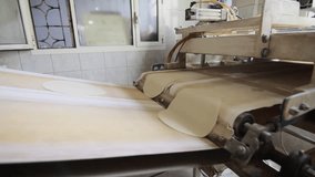 dough on automated belt moving toward the oven covered with flour - Powered by Shutterstock - Get 15% off with code: PIKWIZARD15