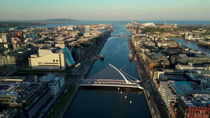Aerial dolly view from Samuel Beckett bridge or know as Harp Bridge on Liffey River, the convention centre and the port of Dublin in the background.