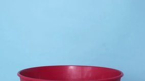 Red trash can filled with crumpled tissues, expired medicines (in plastic), and medical gloves on a blue isolated background - Powered by Shutterstock - Get 15% off with code: PIKWIZARD15