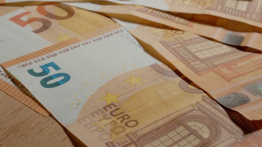 Experience an extreme close up of a 50 euro banknote revealing its unique features and designs. Discover the fine lines, patterns, and colors in this macro perspective.