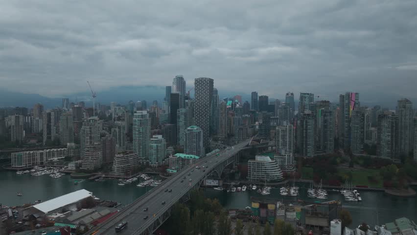 Descending and panning aerial shot of Granville Bridge in downtown Vancouver on a rainy morning in British Columbia, Canada. 4K