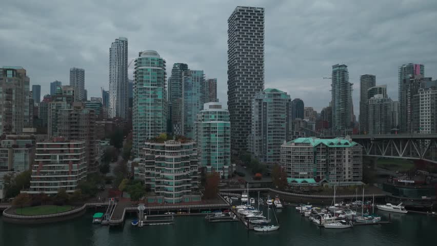 Wide reverse pullback aerial shot of Granville Bridge on a rainy afternoon in Vancouver, British Columbia, Canada. 4K