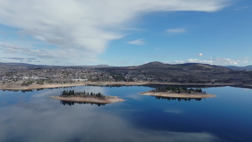 Aerial: Big wide shot of Jindabyne town and surrounding lake in the Snowy mountains, NSW Australia