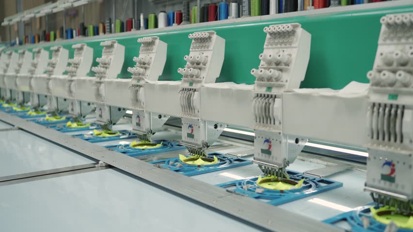 Close-up of Industrial Multi-Head Embroidery Machine Sewing Yellow Fabric