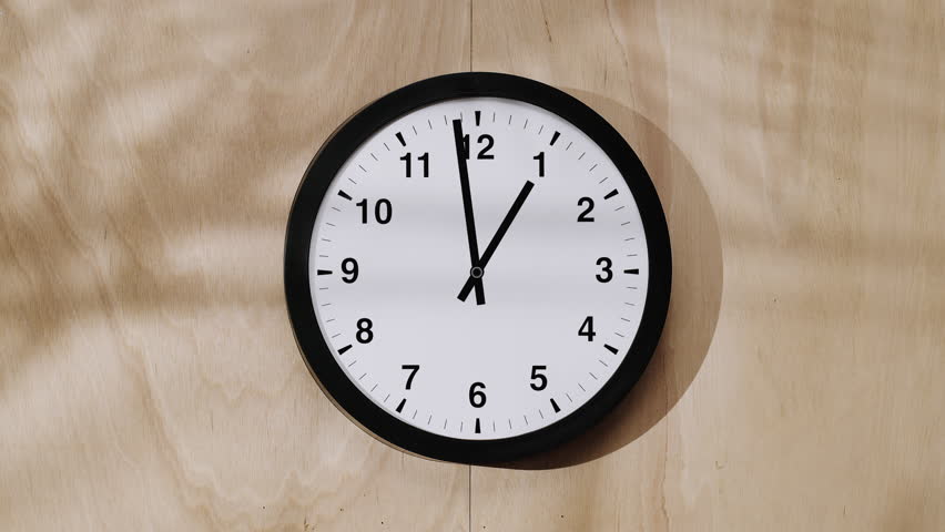Time lapse video of classic black and white wall clock hands against  beige background. A symbol of the transience of time and life.