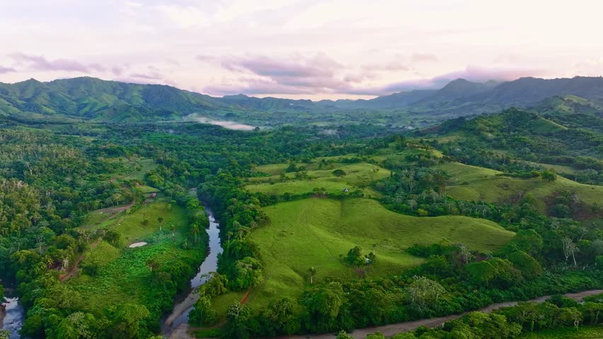 A picturesque landscape of a calm river flowing between tree-lined banks. Mountain stream in a green forest in summer. Vibrant mountain landscape with turquoise river stream, drone view.