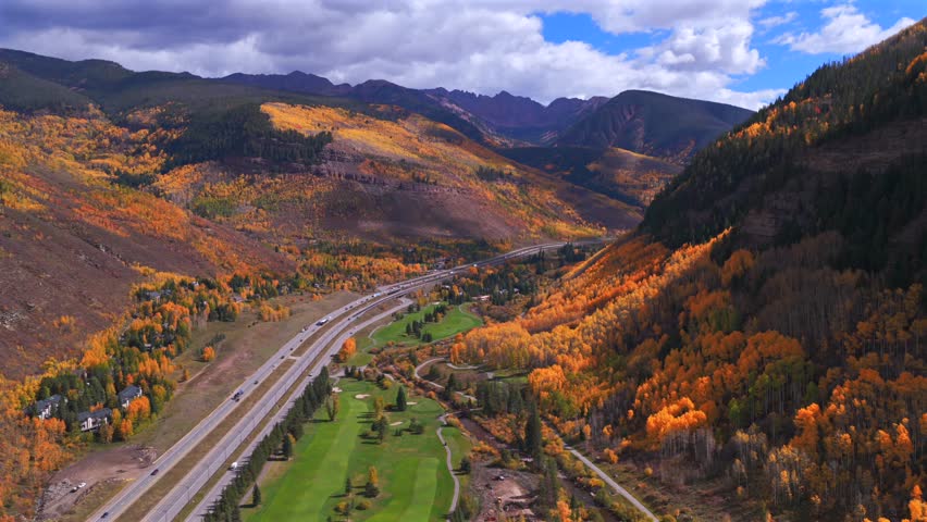 Vail Golf Club Vail Colorado Gore RangeRocky Mountains aerial drone fall autumn Vail Pass cars traffic i70 highway colorful aspen trees morning blue skies sunny clouds forward upwards motion