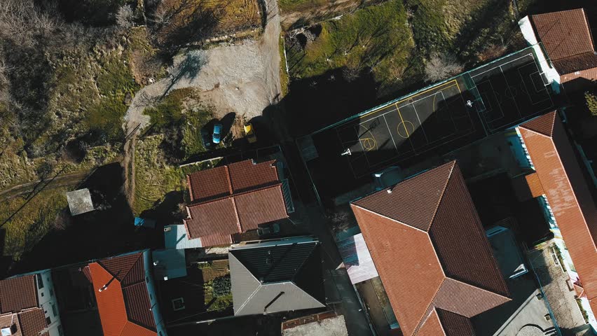 An aerial of a basketball court surrounded by the residential buildings on a sunny day