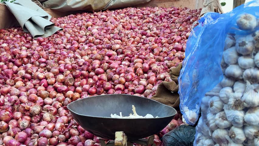 fresh red onions stacked in bulk at vegetable market